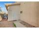 Beige home featuring a white door with sunburst design, small window, and concrete walkway to the entrance at 2435 Paddock Ln, Las Vegas, NV 89156