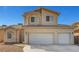 Two story home with a three-car garage and light tan exterior at 2435 Paddock Ln, Las Vegas, NV 89156