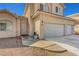 Two story home with a three-car garage and light tan exterior at 2435 Paddock Ln, Las Vegas, NV 89156