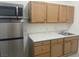 Kitchenette features microwave, stainless steel fridge, sink, and wooden cabinetry at 2435 Paddock Ln, Las Vegas, NV 89156