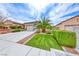 Beautiful single story home featuring desert landscaping, green grass and a spacious driveway at 2561 Cosmic Dust St, Henderson, NV 89044