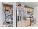 Functional kitchen with stainless refrigerator and a fully stocked pantry for storage at 2561 Cosmic Dust St, Henderson, NV 89044