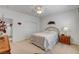 Bright bedroom featuring a ceiling fan, neutral carpet, and a comfortable bed with decorative accents at 2727 Warm Rays Ave, Henderson, NV 89052