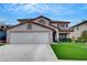 Charming two-story home with a two-car garage and well-manicured lawn creates a welcoming curb appeal at 2727 Warm Rays Ave, Henderson, NV 89052