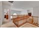 Second story hallway with natural wood railing and neutral colored walls at 2727 Warm Rays Ave, Henderson, NV 89052