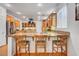 Open kitchen boasts wood cabinetry, granite countertops, bar seating, and stainless steel appliances at 2727 Warm Rays Ave, Henderson, NV 89052