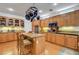 Bright kitchen featuring wood cabinets, a central island with seating, and plenty of counter space at 2727 Warm Rays Ave, Henderson, NV 89052