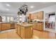 Open kitchen layout with a central island, wood floors, and seamless integration with the dining area at 2727 Warm Rays Ave, Henderson, NV 89052