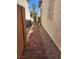 Side yard brick walkway with neutral tones, with an AC unit and gravel along the house wall at 2727 Warm Rays Ave, Henderson, NV 89052