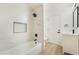 Beautiful white-tiled bathroom showcasing modern bathtub and black hardware at 2958 Al De La St, Las Vegas, NV 89146