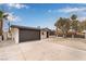 Exterior shot of a single-story home featuring a desert landscape, driveway, and a black garage door at 2958 Al De La St, Las Vegas, NV 89146