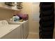 Functional laundry room with a washing machine, dryer, storage shelves, and cleaning supplies at 3169 Crystal Moon Rd, Henderson, NV 89052