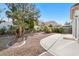 This backyard features gravel landscape, mature trees, and a concrete patio at 319 Fox Lake Ave, Las Vegas, NV 89148