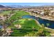 Scenic aerial view of the golf course with palm trees, a lake, and mountain views in the distance at 319 Fox Lake Ave, Las Vegas, NV 89148