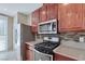 Close-up of a kitchen with stainless-steel appliances and dark wood cabinetry, providing a modern cooking space at 319 Fox Lake Ave, Las Vegas, NV 89148