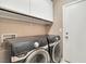 Functional laundry room equipped with Samsung front-loading washer and dryer, plus overhead storage at 319 Fox Lake Ave, Las Vegas, NV 89148