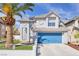 Charming two-story home features a vibrant blue garage door and mature landscaping with a tall palm tree at 3329 Buffalo Narrows Cir, Las Vegas, NV 89129