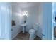 Cozy half bathroom featuring a pedestal sink, oval mirror, and a toilet with wood look flooring at 3439 Cottage Canyon St, Laughlin, NV 89029