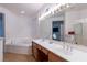 Bathroom featuring dual sinks, soaking tub, and wood-look flooring at 3439 Cottage Canyon St, Laughlin, NV 89029