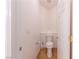 Compact half-bathroom with wood-look flooring and a toilet with white walls at 3439 Cottage Canyon St, Laughlin, NV 89029