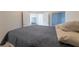 A comfortable bedroom features a bed, open double doors, wood flooring and a window with natural light at 3439 Cottage Canyon St, Laughlin, NV 89029
