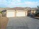 Three car garage home showcasing desert landscaping and an extra long driveway at 3439 Cottage Canyon St, Laughlin, NV 89029