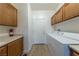 Functional laundry room featuring a washer, dryer, storage cabinets, and wood grain flooring at 3439 Cottage Canyon St, Laughlin, NV 89029