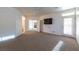 Bright living room featuring neutral carpet, ceiling fan, and access to the exterior through a glass paneled door at 3439 Cottage Canyon St, Laughlin, NV 89029