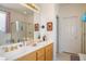 Bright bathroom with dual sinks, a large mirror, and a gold-framed shower at 3491 Cottage Thistle Dr, Laughlin, NV 89029