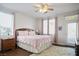 Relaxing bedroom with a plush rug, soft pink bedding, wood-look flooring and windows overlooking the backyard at 3491 Cottage Thistle Dr, Laughlin, NV 89029
