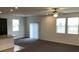 The neutral carpeted living area has a ceiling fan and multiple windows for ample light at 3530 E Moffat Ave, Pahrump, NV 89061