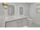 Modern bathroom featuring dual vanity, backlit mirrors, and sleek white cabinets and fixtures at 4108 Freel Peak Ct, Las Vegas, NV 89129