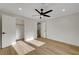 Bright, open bedroom with light hardwood flooring, white walls, ceiling fan, and open closet at 4108 Freel Peak Ct, Las Vegas, NV 89129
