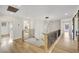 Upstairs hallway with decorative railings, barn door, and modern lighting fixture at 4108 Freel Peak Ct, Las Vegas, NV 89129