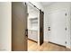 Hallway featuring modern barn door to pantry and a white entry door with matte black hardware at 4108 Freel Peak Ct, Las Vegas, NV 89129