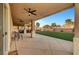 Covered patio with ceiling fans overlooking a manicured lawn and palm trees at 4108 Freel Peak Ct, Las Vegas, NV 89129