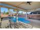 This covered patio offers views of the pool, spa, and palm trees that complete the backyard oasis at 4108 Freel Peak Ct, Las Vegas, NV 89129