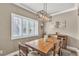 Bright dining room showcasing a modern chandelier, plantation shutters, and a wooden table at 4247 Jordanville St, Las Vegas, NV 89129