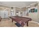 Open-concept living room with a travertine floor, pool table, and natural light at 4247 Jordanville St, Las Vegas, NV 89129