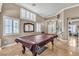 Spacious living area featuring a pool table, large windows, and tile flooring at 4247 Jordanville St, Las Vegas, NV 89129