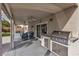 Covered patio with ceiling fans, outdoor seating, and a built-in grill for outdoor entertaining at 4247 Jordanville St, Las Vegas, NV 89129