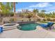 Inviting backyard featuring a pool, hot tub, lounge chairs, and lush landscaping at 4247 Jordanville St, Las Vegas, NV 89129