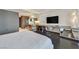 Bedroom with modern lighting, built-in desk area, and large TV for a comfortable space at 4381 W Flamingo Rd # 1609, Las Vegas, NV 89103