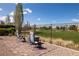 A tranquil backyard featuring a brick patio, offering seating and scenic views of the lush golf course beyond at 5224 E San Palo Dr, Pahrump, NV 89061