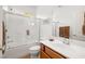Well-lit bathroom featuring a shower-over-tub with glass doors and a vanity with double sinks at 5224 E San Palo Dr, Pahrump, NV 89061