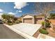 Inviting single-story home featuring a well-manicured lawn, desert landscaping, and a spacious three-car garage at 5224 E San Palo Dr, Pahrump, NV 89061