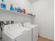 Functional laundry room with white washer and dryer, complemented by ample shelving at 5224 E San Palo Dr, Pahrump, NV 89061