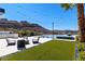 Backyard patio and a putting green with a pool and spa, all with views of the Las Vegas mountains at 535 Serenity Point Dr, Henderson, NV 89012