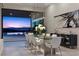 Elegant dining room with modern chandelier, glass table, and sliding doors to the pool at 535 Serenity Point Dr, Henderson, NV 89012