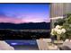 Elegant dining area showcasing modern pendant lighting and an expansive view of the illuminated cityscape at dusk at 535 Serenity Point Dr, Henderson, NV 89012